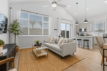 A living room with a grey couch and a wooden coffee table.